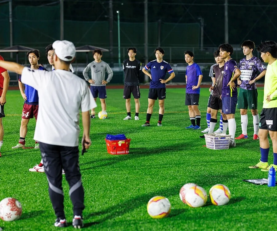 夜間練習で監督の話を聞く選手たち
