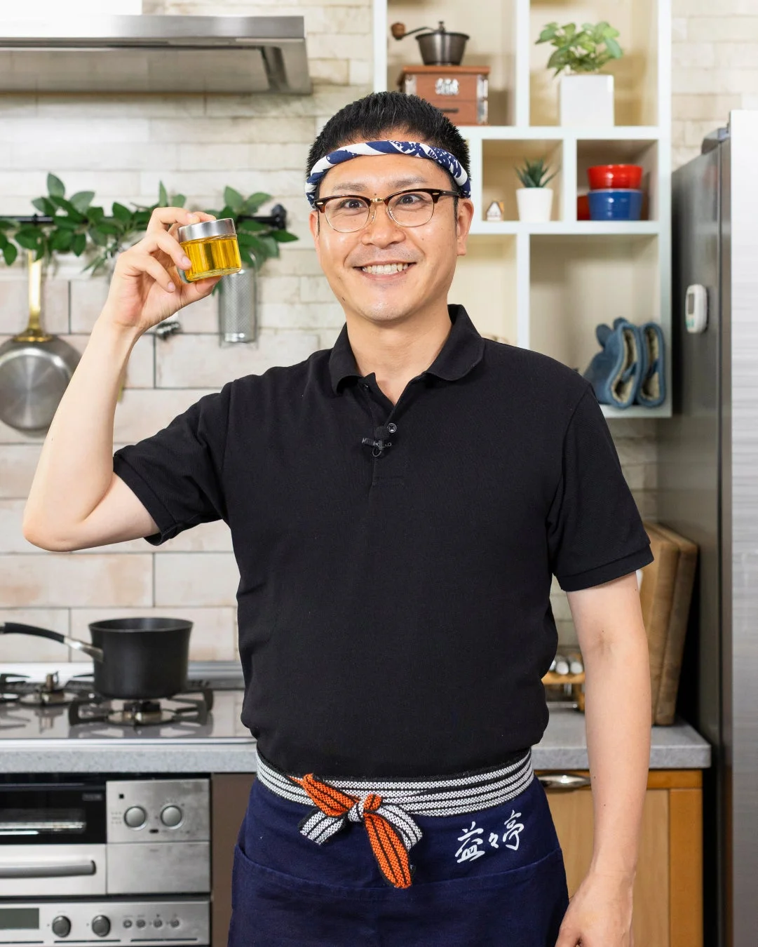 キッチンで笑顔の男性が調味料の瓶を持っている様子