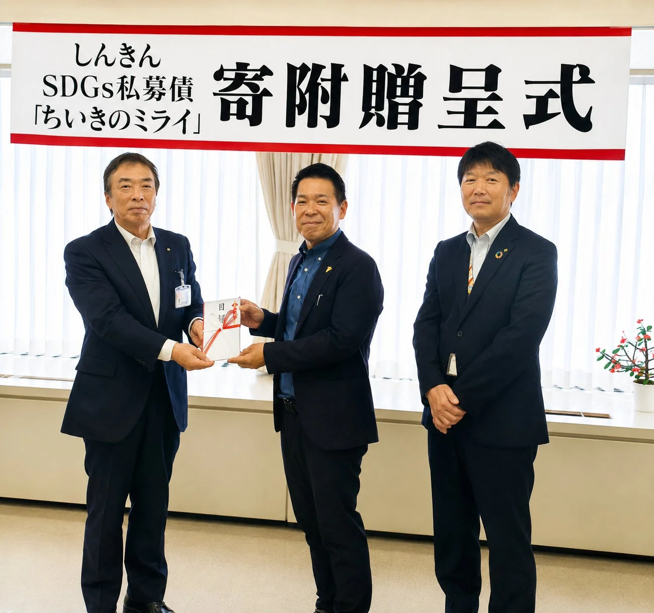 寄附贈呈式で目録が渡される様子