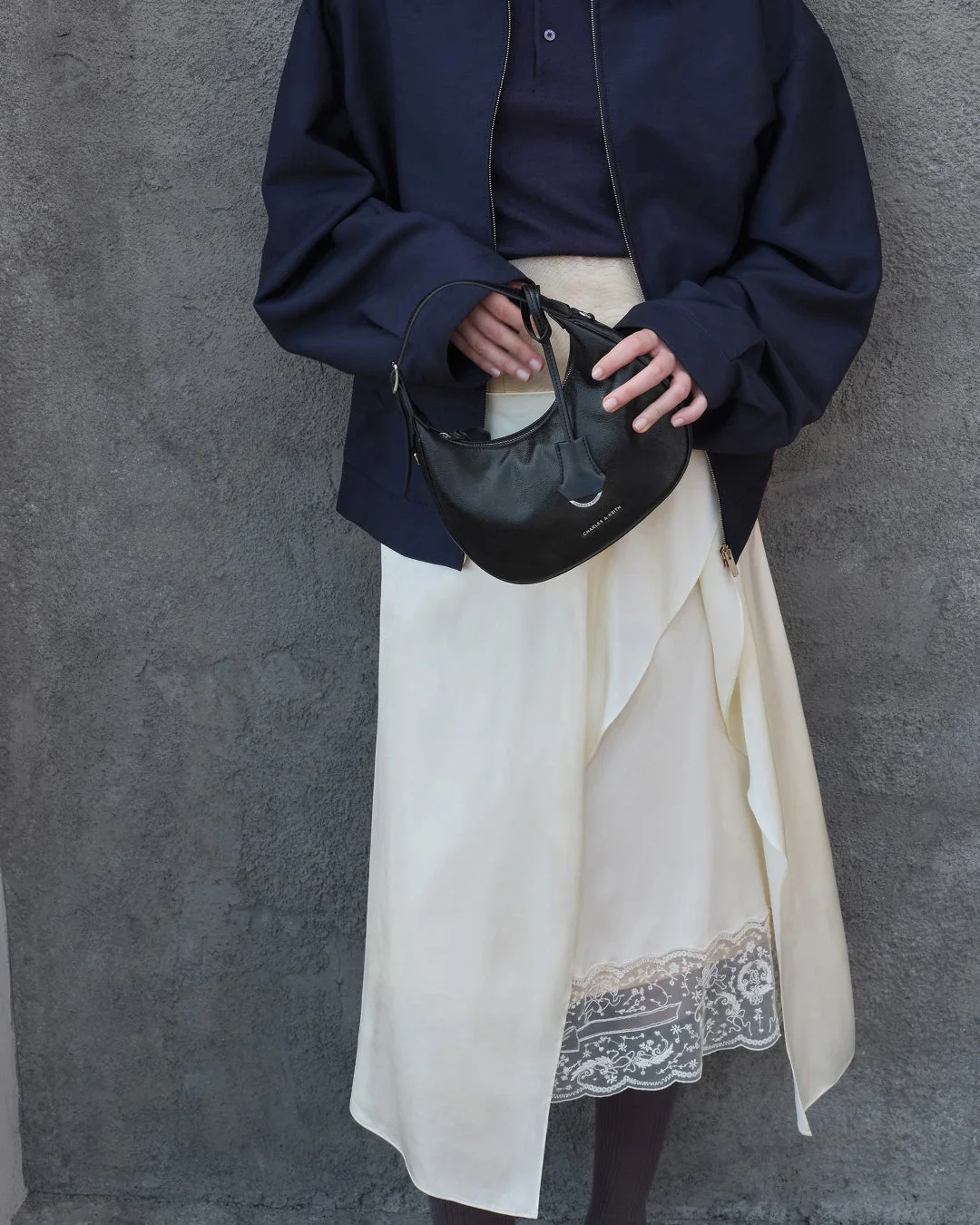 CHARLES & KEITHの黒いショルダーバッグを持った女性