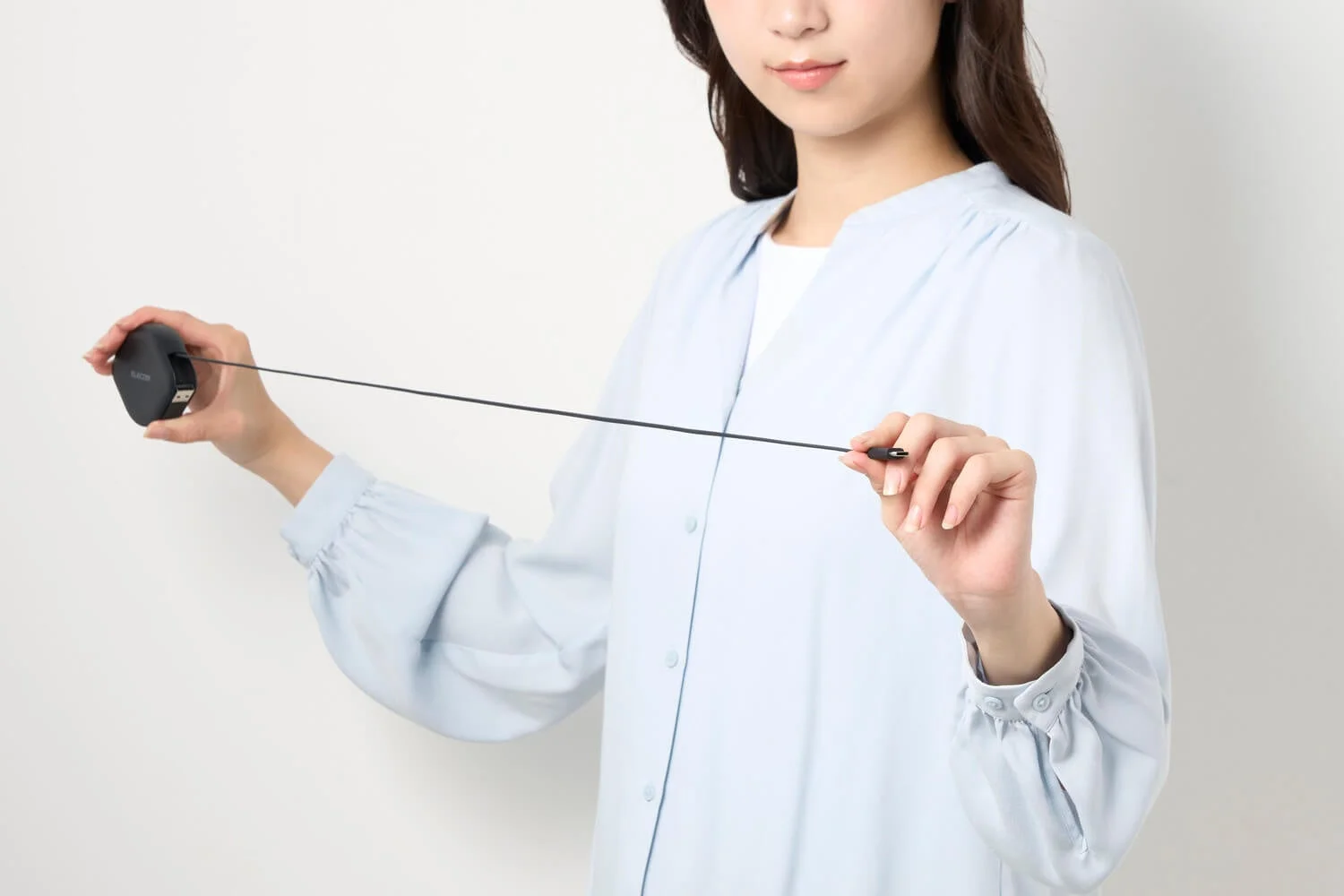 女性がケーブルを伸ばしている画像
