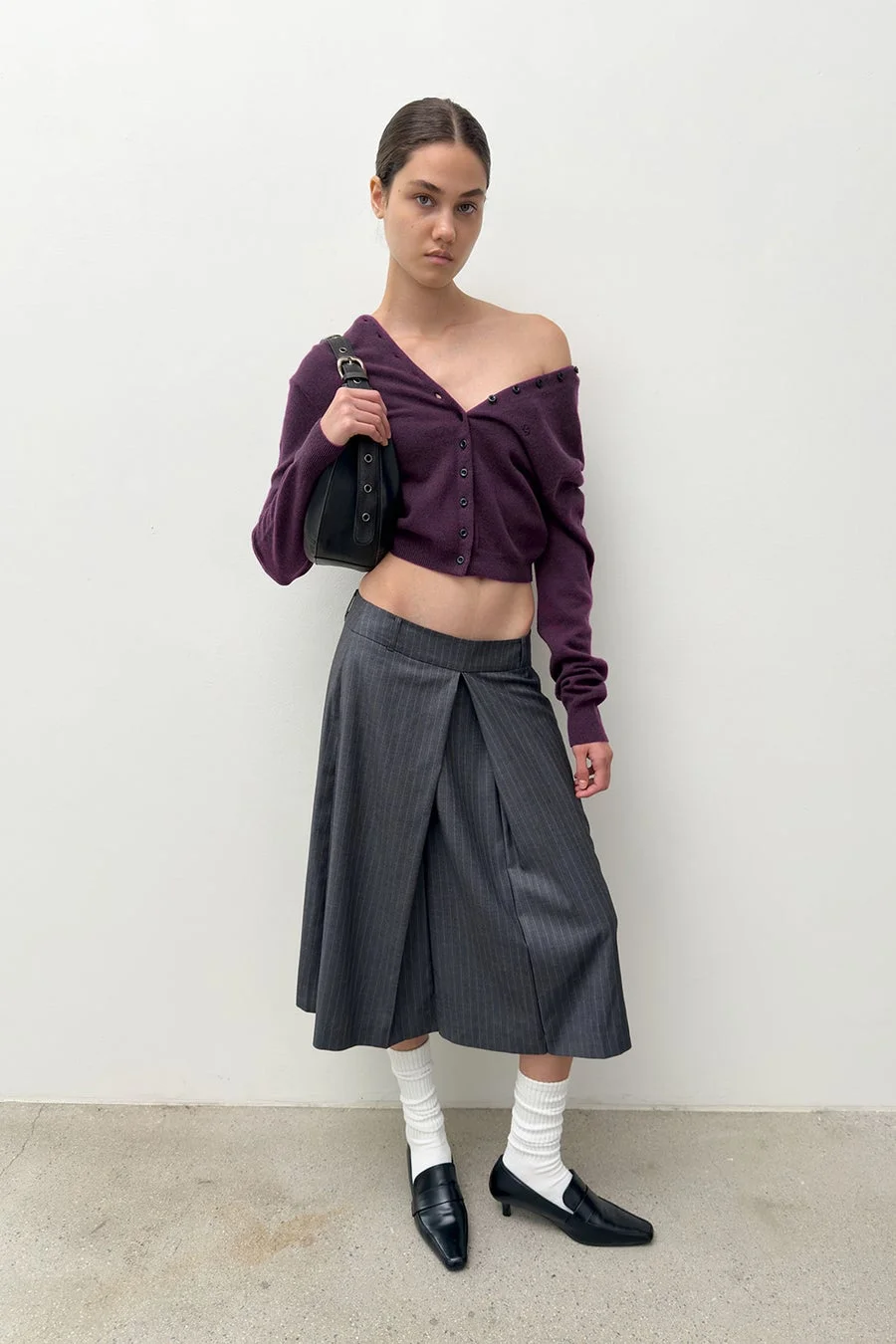 DIAGONALのカーディガンとスカートを着用した女性