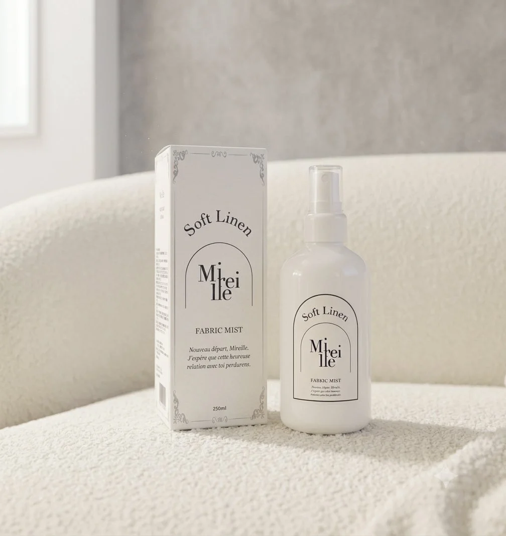 「Soft Linen Mireille FABRIC MIST」の白いスプレーボトルとパッケージが、清潔感のある背景に置かれています。製品は布用ミストで、容量は250ml。シンプルで洗練されたデザインが特徴です。