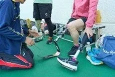 義足を装着しているアスリートたちが、練習や競技に向けて準備をしている様子を捉えた画像です。