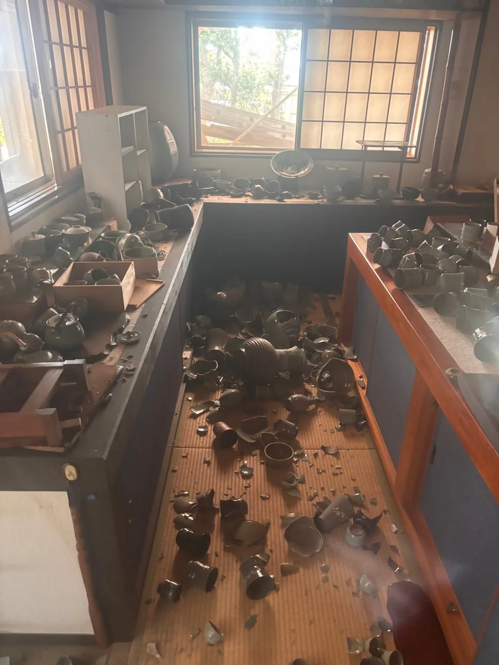 割れた陶器や食器が床一面に散らばる部屋