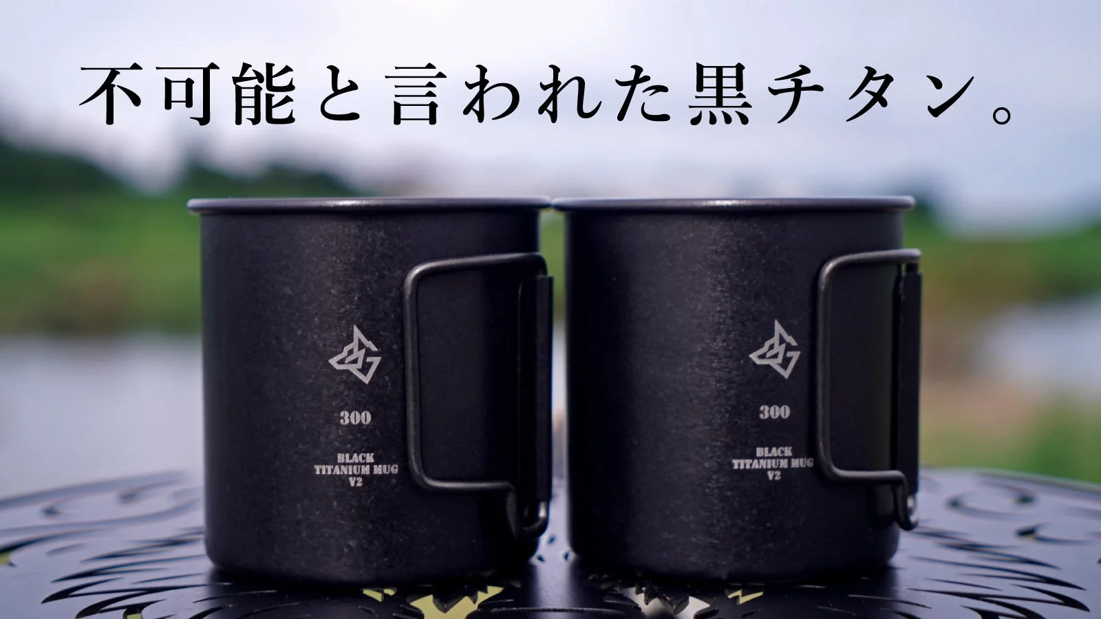 屋外に置かれた2つの黒いチタン製マグカップ