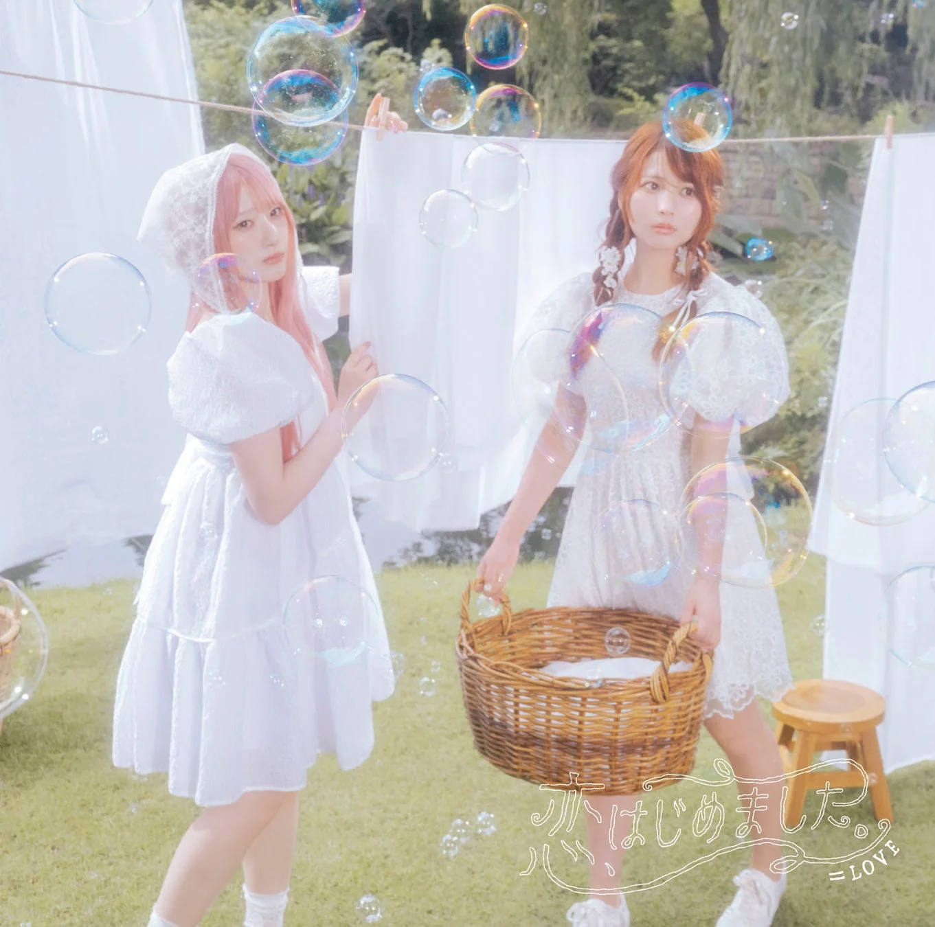 白いワンピースを着た女性二人組がシャボン玉が舞う中で洗濯物を干す写真