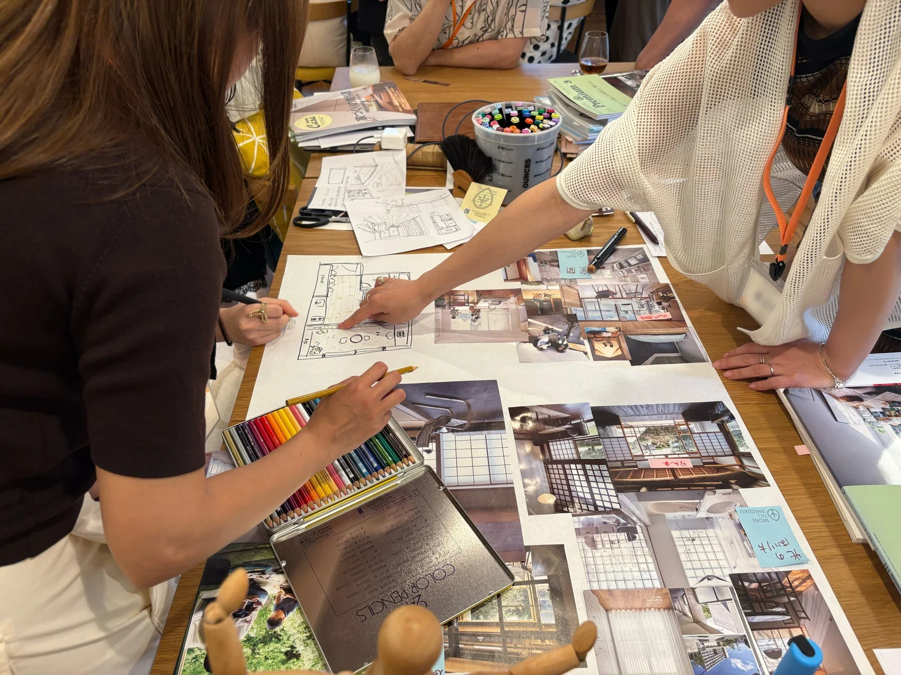 間取り図やインテリアのコラージュを見ながら話し合う女性たち