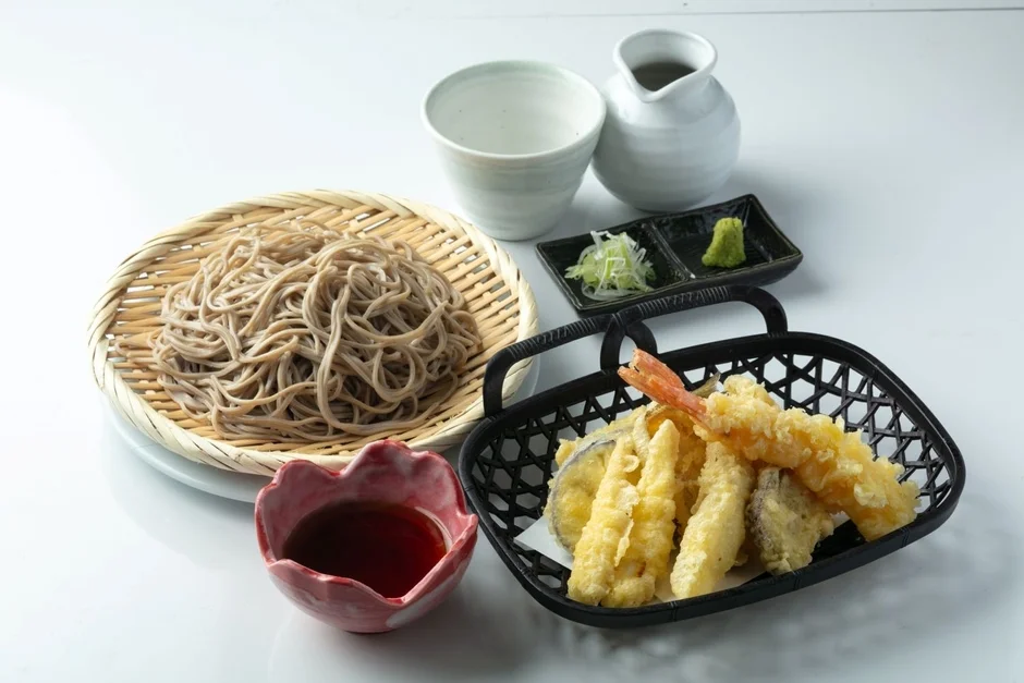 竹ざるに盛られたそばと海老や野菜の天ぷら