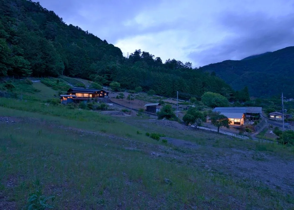 夕暮れ時の山間部に位置する集落の風景