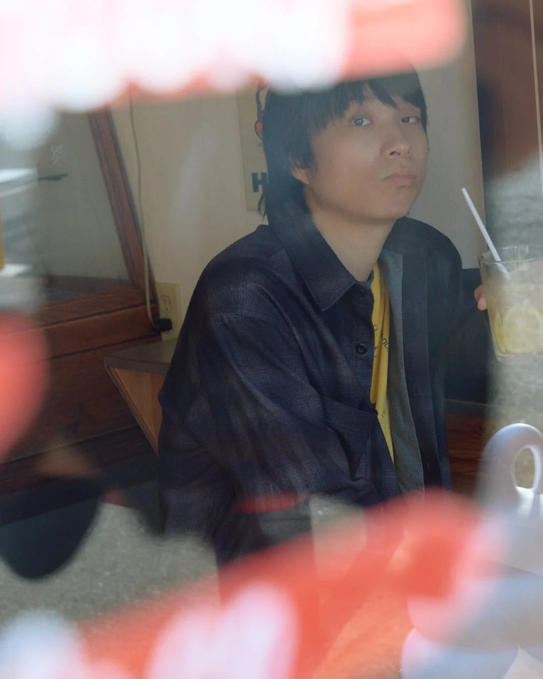 カフェでドリンクを持つ尾崎世界観さん