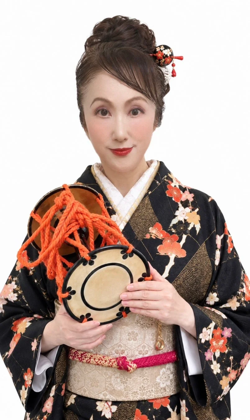 黒地に華やかな桜と紅葉の柄の着物を着た日本人女性が、伝統楽器の鼓を手に優しく微笑んでいる