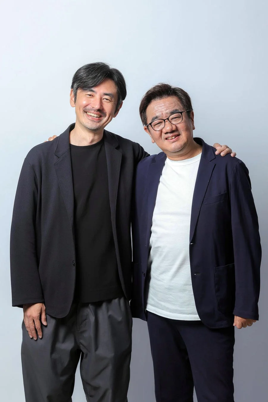 肩を組み笑顔を見せる2人の男性