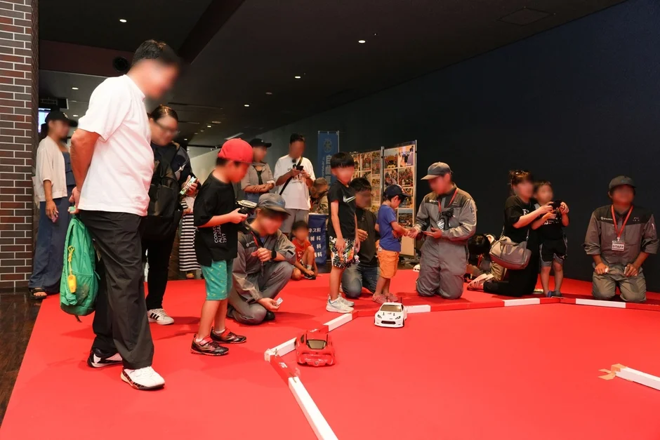 子供たちがラジコンカーを操作して遊んでいる様子