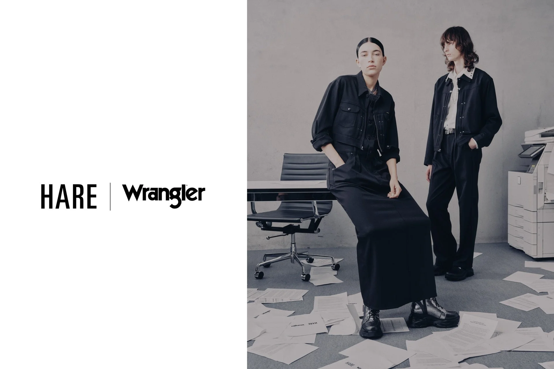 HAREとWranglerのコラボレーションを示す画像。オフィスのような空間で、黒いファッションに身を包んだ男女モデルがポーズをとっており、床には書類が散乱している。クールでモダンな雰囲気のファッション広告です。