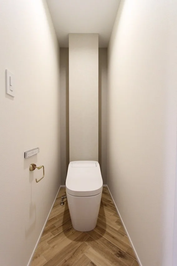 シンプルな白い便器が設置された、清潔感のあるモダンなトイレ空間