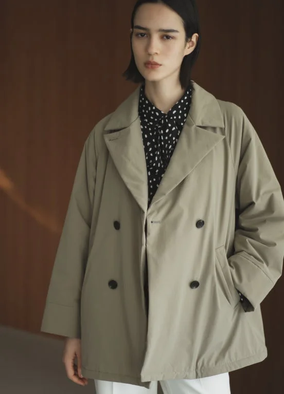 ベージュのショートコートとドット柄シャツ