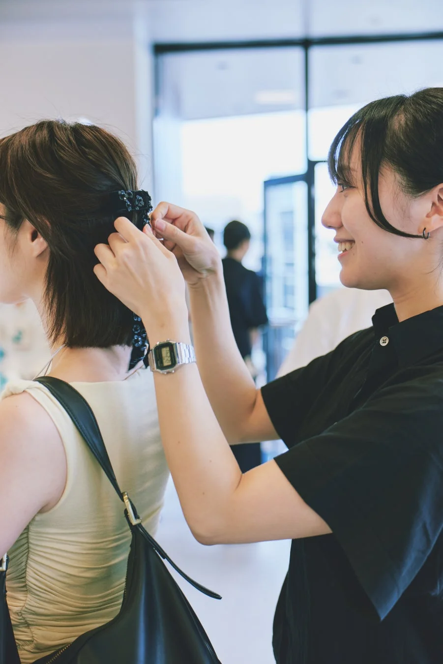 女性の髪にヘアクリップを使いヘアアレンジしている様子