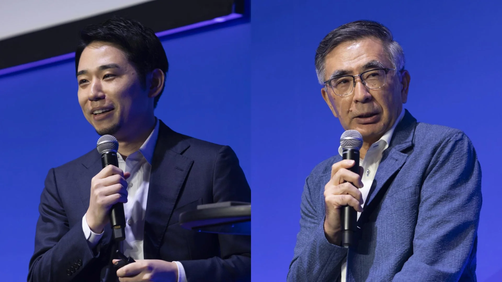 青い背景の前で、マイクを持って話す2人の男性の姿を捉えた画像です。講演会やビジネスイベントでのトークセッションの様子を思わせます。