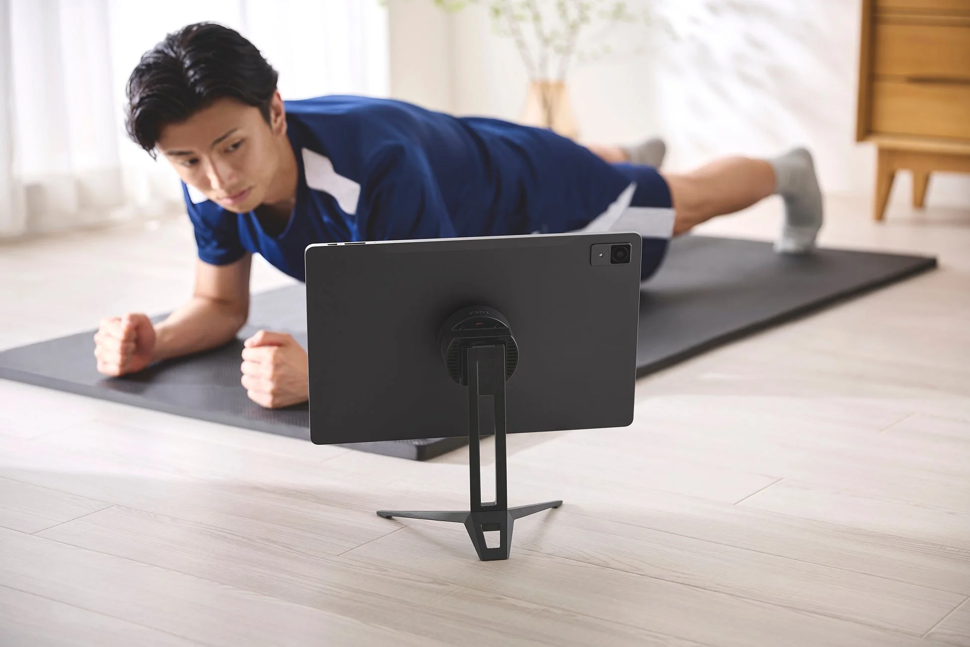 トレーニング中にタブレットスタンドを使う男性