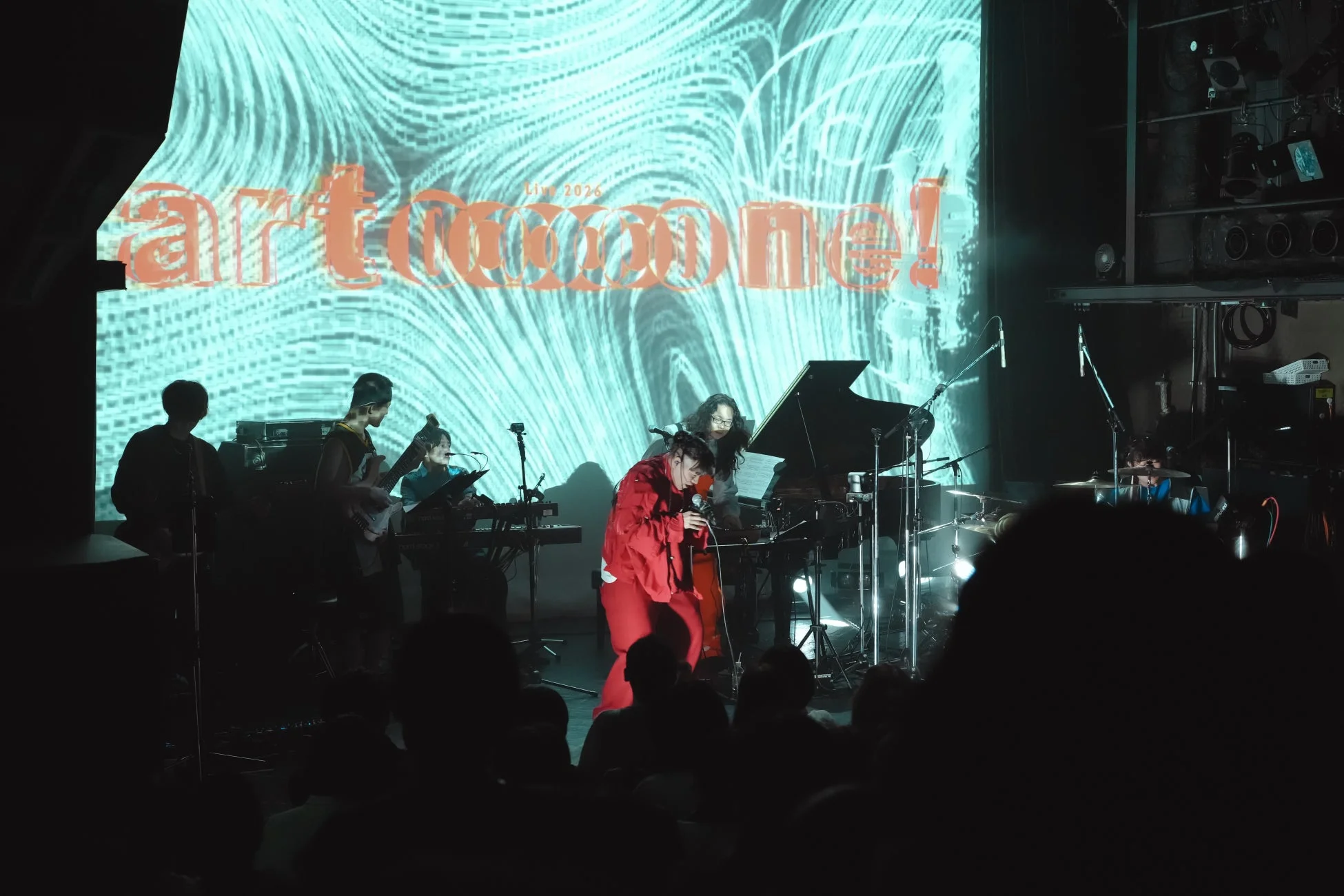 ステージ上でバンドがライブパフォーマンスを行っている様子。