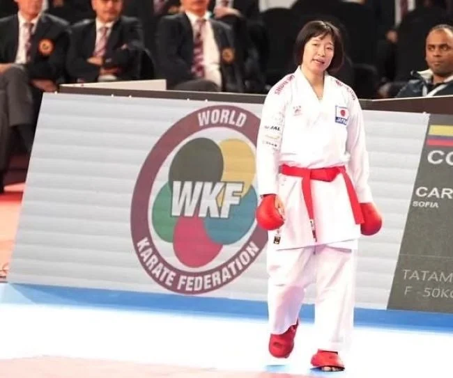 白い道着と赤い帯、赤いグローブを身につけた日本人女性空手選手