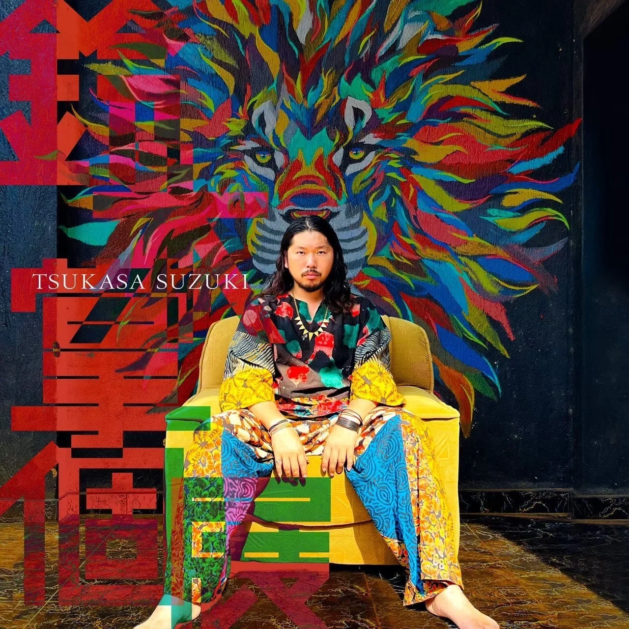 カラフルなライオンの壁画の前で座る画家・アーティスト鈴木 掌さん