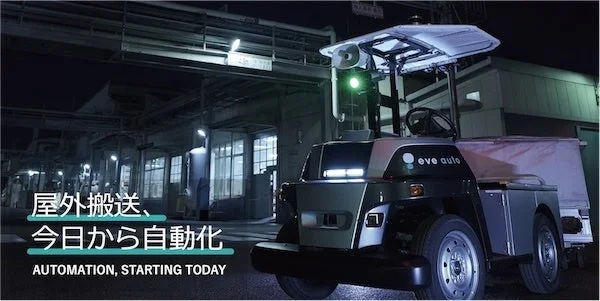 夜の屋外工場のような場所で、自律走行型の搬送車両「eve auto」が停車している様子