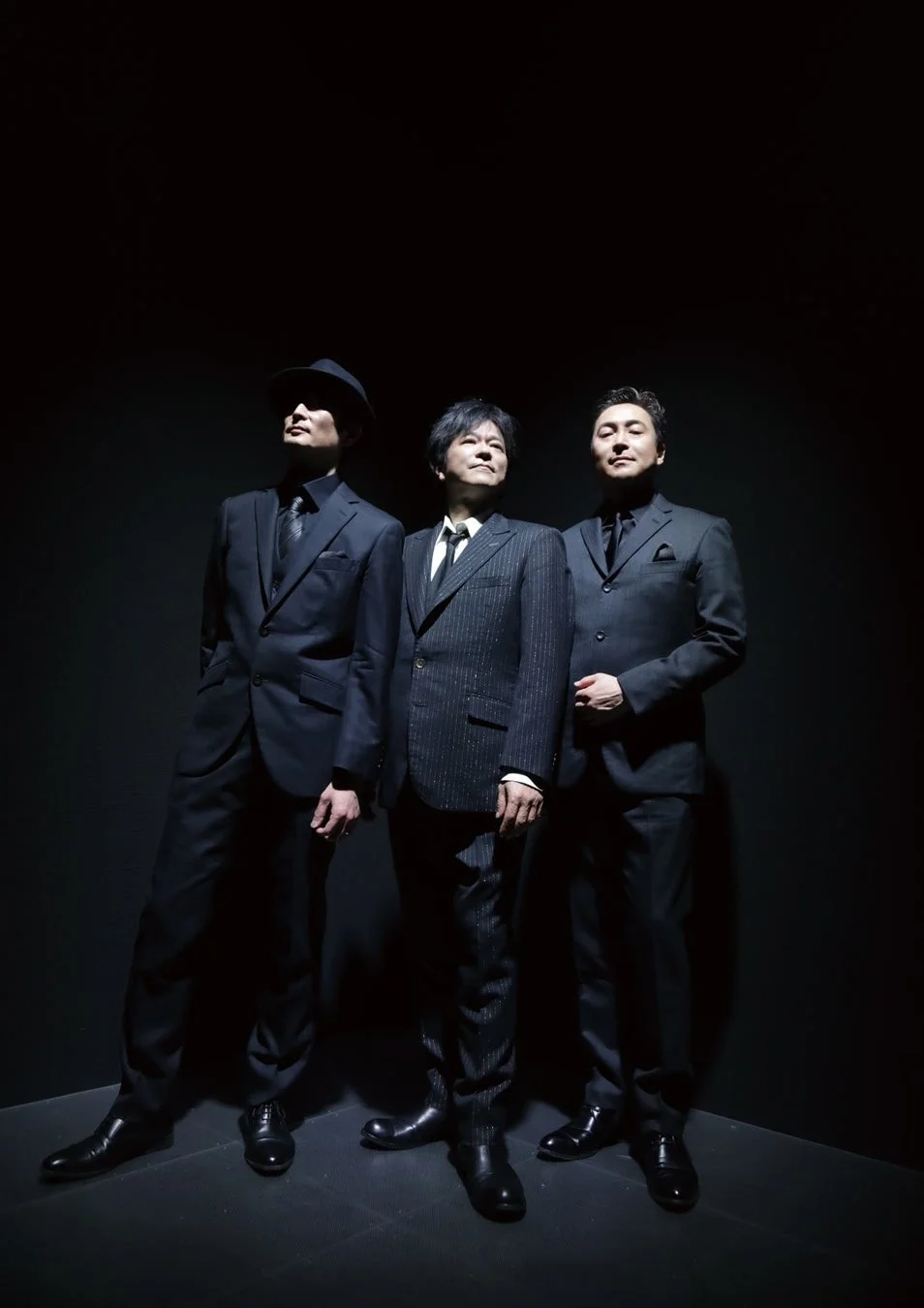 スポットライトを浴びる3人の男性アーティスト