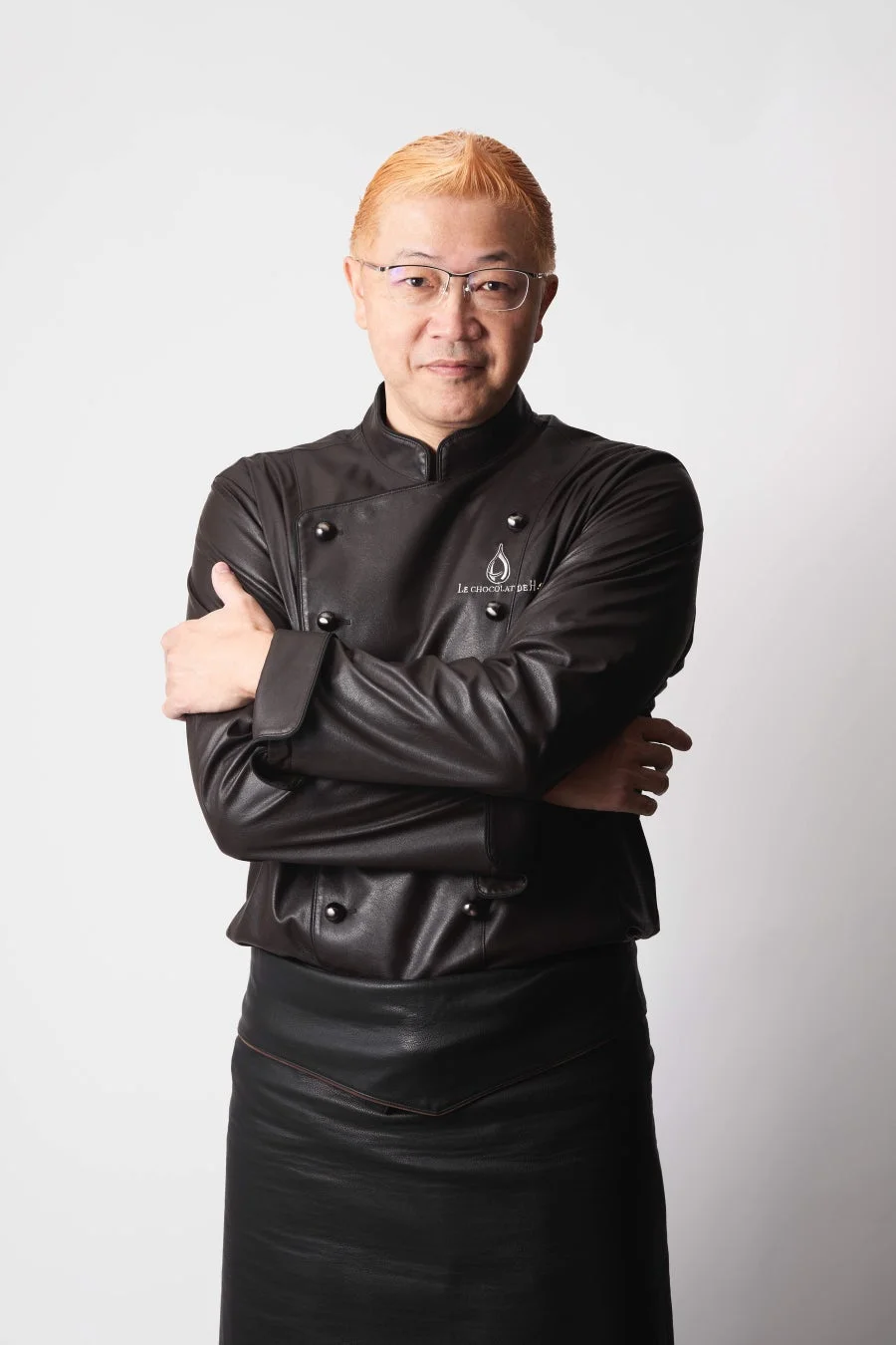 革ジャンとエプロンを着用した辻󠄀口博啓シェフ