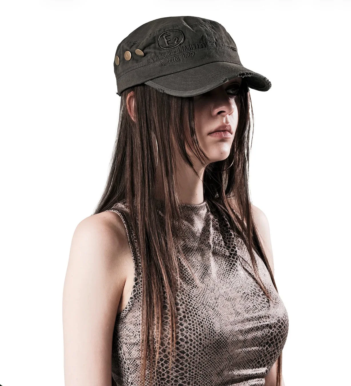 ミリタリーキャップとスネーク柄トップスの女性