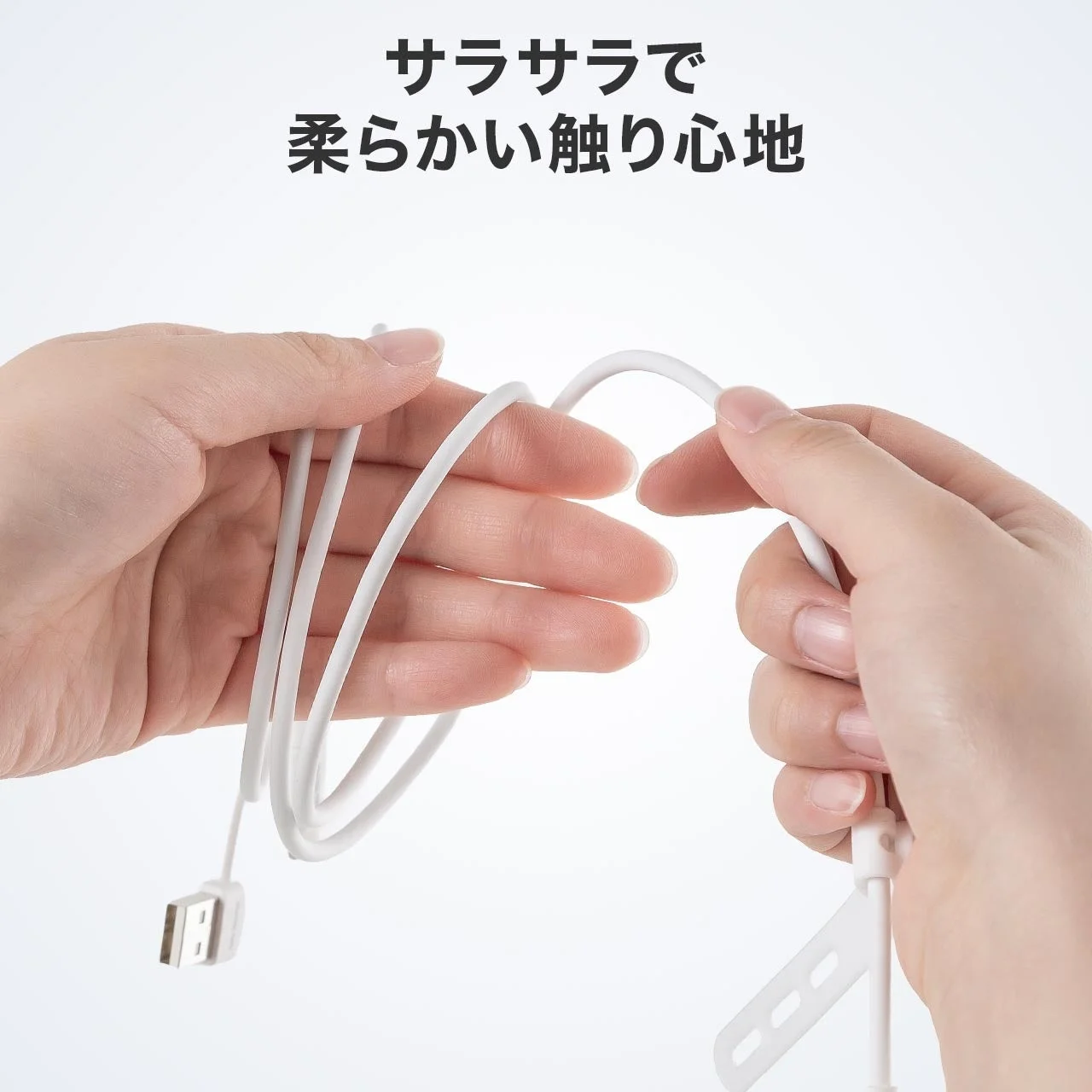 白いケーブルを両手で持ち、その触り心地の良さを表現している画像