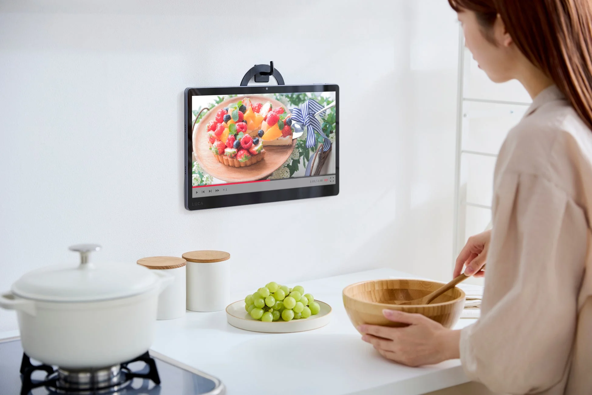 タブレットリングで壁掛けにする女性