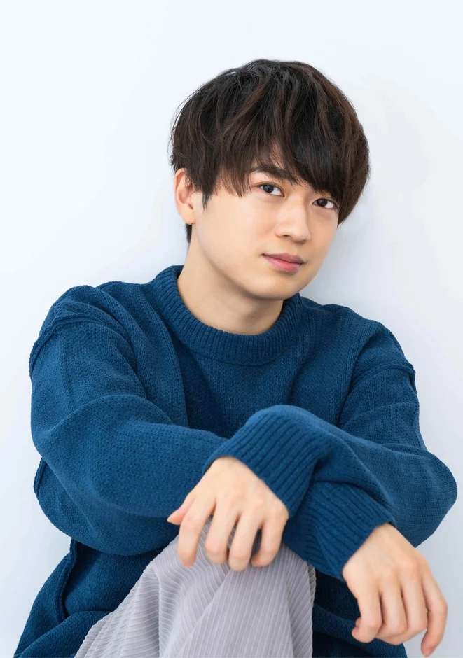 青いセーターを着た若い男性