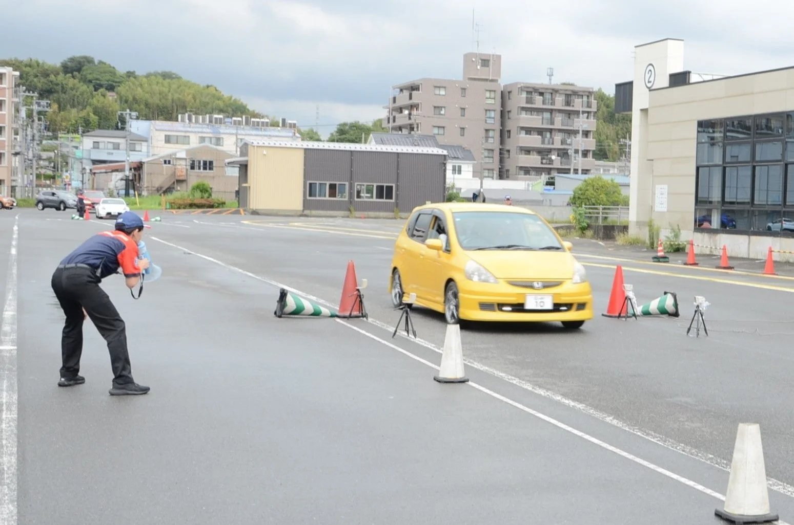 運転教習所でインストラクターがメガホンで指導している様子