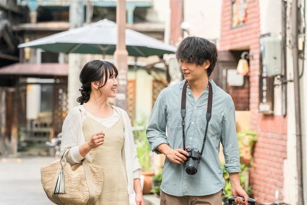街並みを笑顔で歩く若いカップル