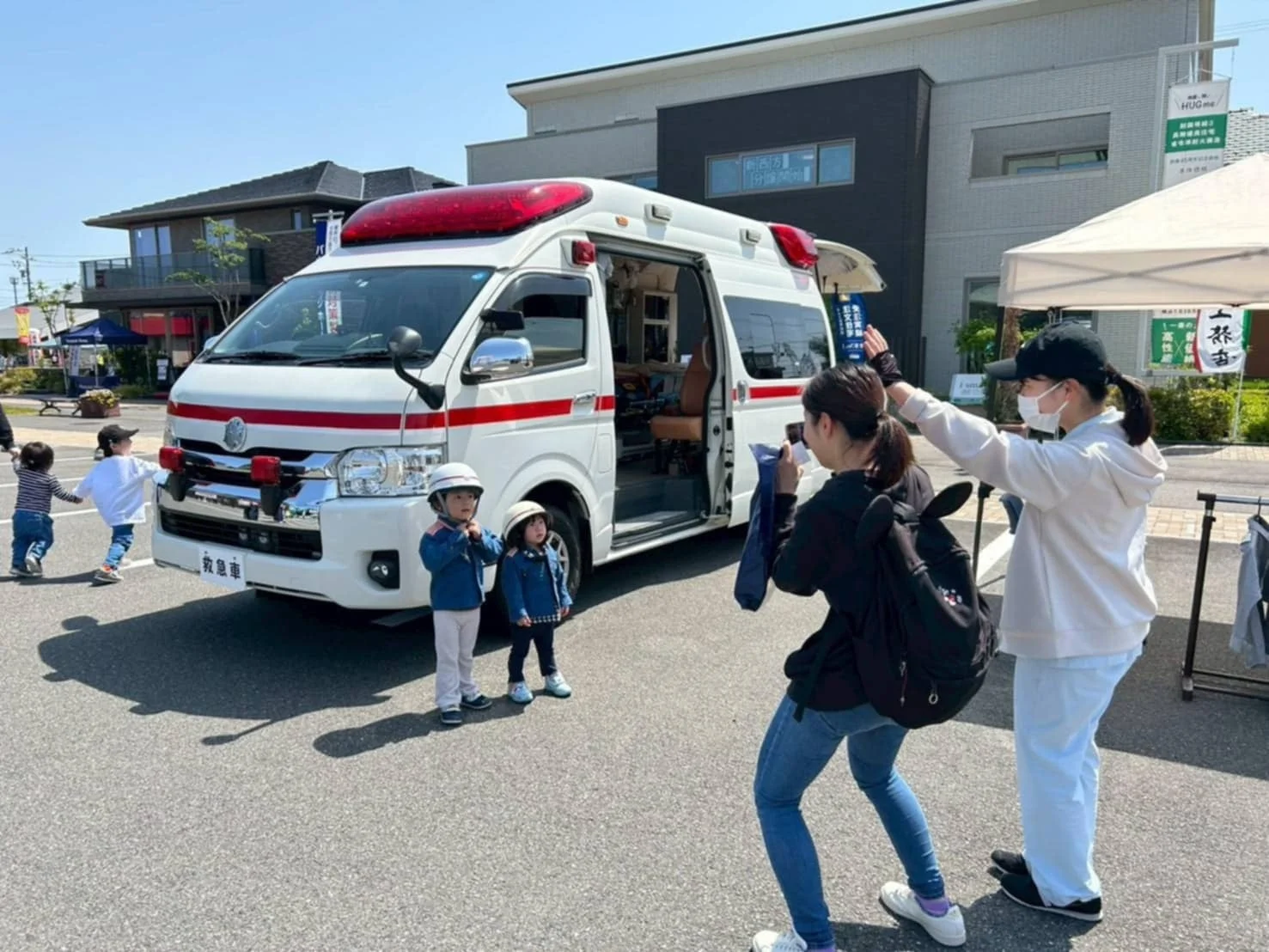 屋外イベントで子供たちが救急車と触れ合っている様子
