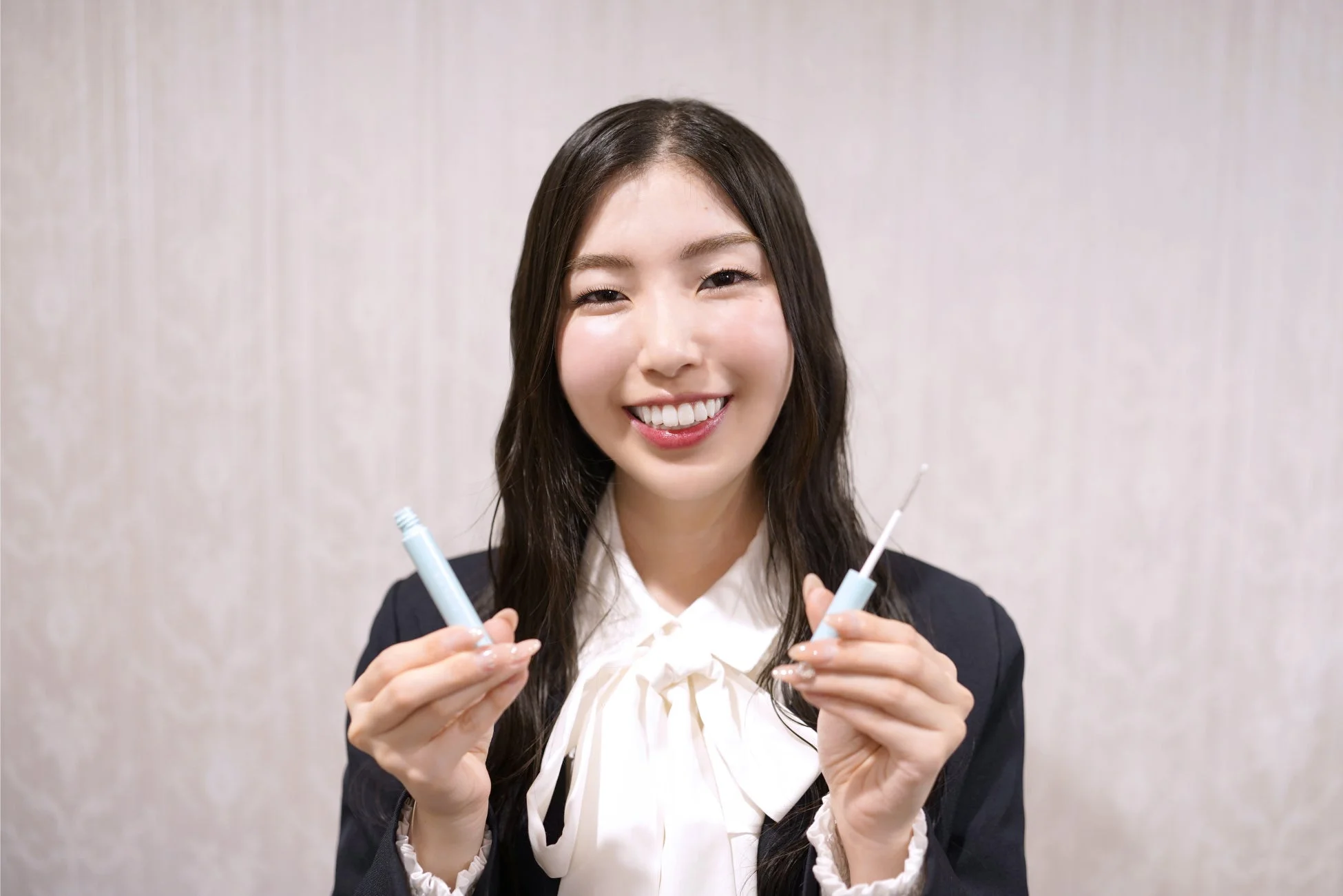 アイリストの山本明日香さんがビオルチアアイラッシュセラムを持つ写真