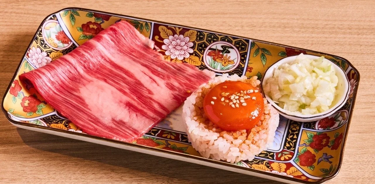 生肉、ご飯、卵黄、薬味の豪華な盛り合わせ